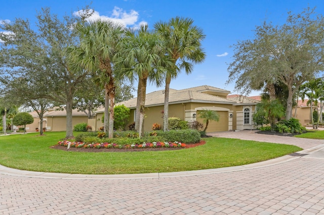 mediterranean / spanish-style home featuring a garage and a front lawn