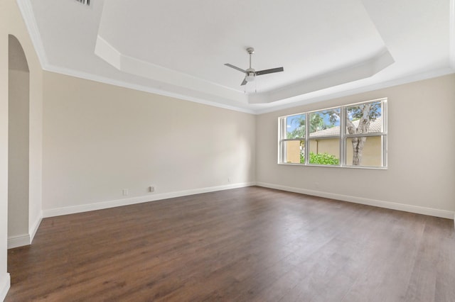 spare room with dark hardwood / wood-style flooring, a raised ceiling, and crown molding