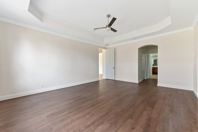 unfurnished room with a raised ceiling, ceiling fan, dark hardwood / wood-style floors, and ornamental molding