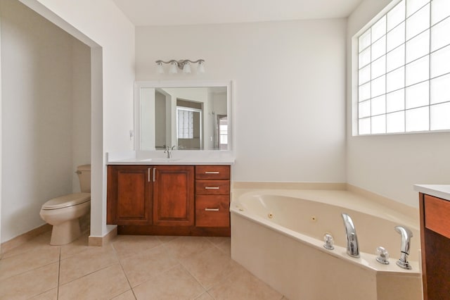 bathroom featuring tile patterned floors, vanity, toilet, and a bathing tub