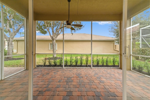 unfurnished sunroom with ceiling fan