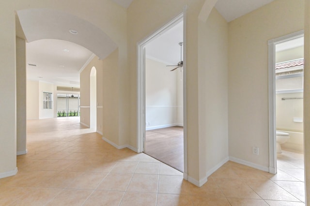 corridor with light tile patterned floors and ornamental molding