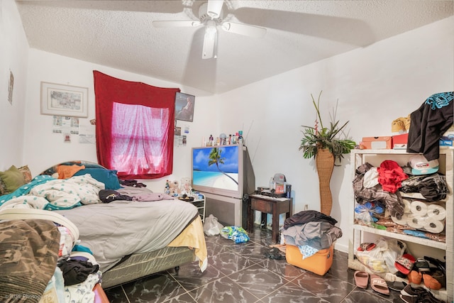 bedroom with ceiling fan and a textured ceiling