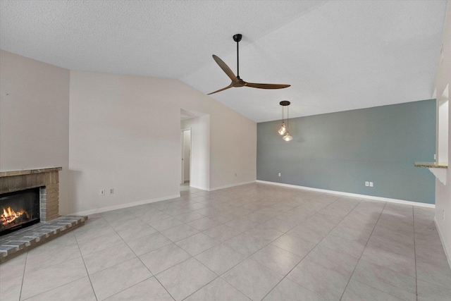 unfurnished living room featuring a textured ceiling, ceiling fan, lofted ceiling, and a brick fireplace