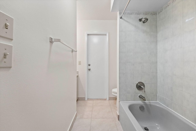 bathroom with toilet, tile patterned floors, and tiled shower / bath