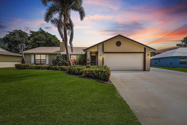 ranch-style home featuring a lawn and a garage