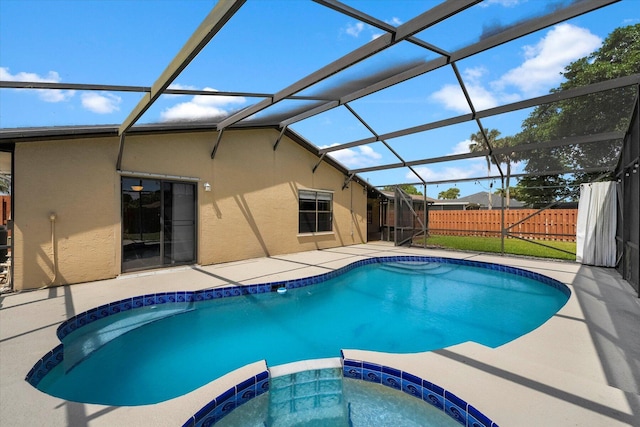 view of swimming pool with glass enclosure, a patio area, and an in ground hot tub