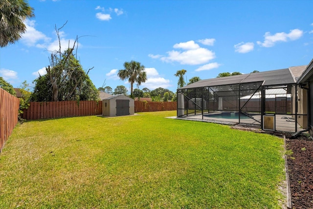 view of yard with a fenced in pool, glass enclosure, and a storage unit