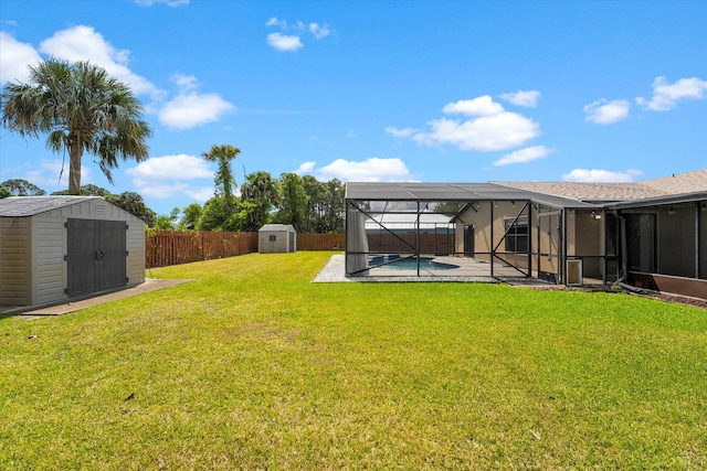 view of yard with a lanai, a patio area, a swimming pool, and a shed