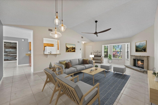 living room featuring a brick fireplace, ceiling fan, light tile patterned flooring, and vaulted ceiling