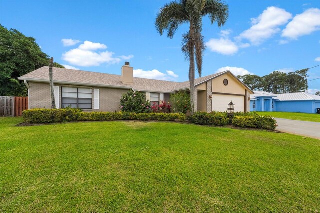 single story home featuring a garage and a front yard