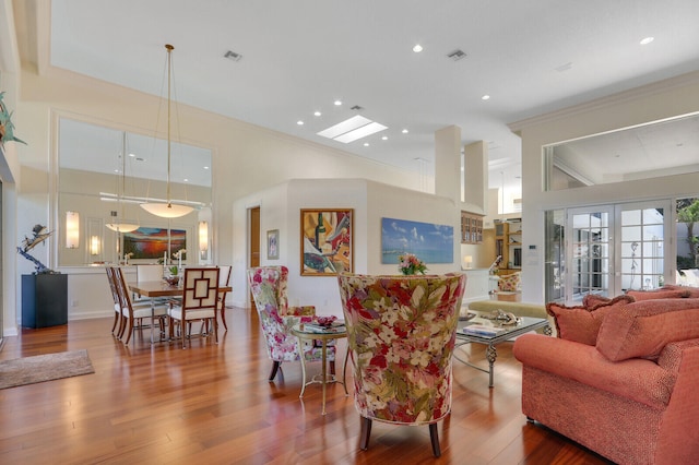 living room with hardwood / wood-style floors, ornamental molding, and french doors