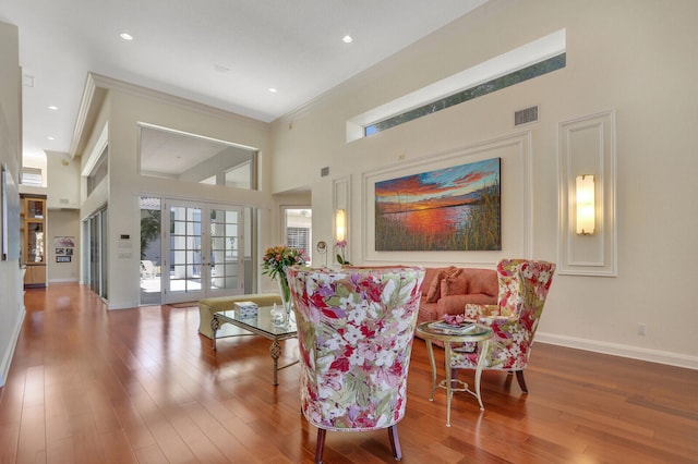 living room featuring wood-type flooring, high vaulted ceiling, french doors, and crown molding