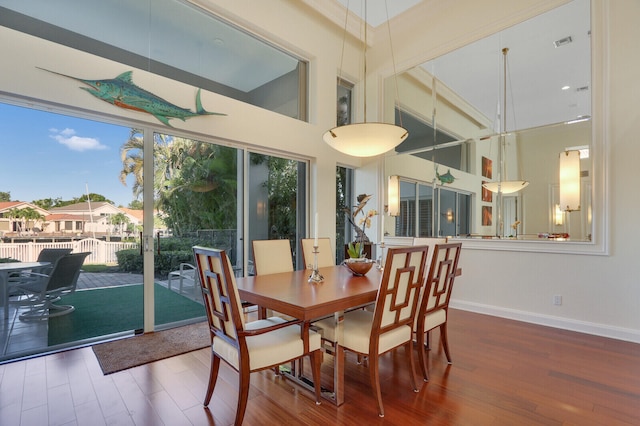 dining area featuring a high ceiling and wood-type flooring