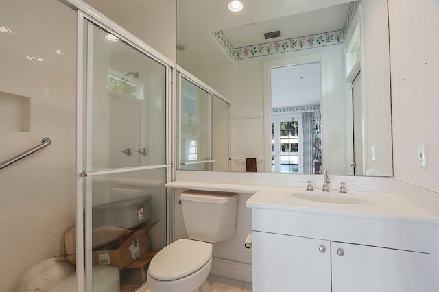 bathroom featuring vanity, a shower with shower door, and toilet