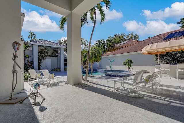 view of patio with a swimming pool with hot tub