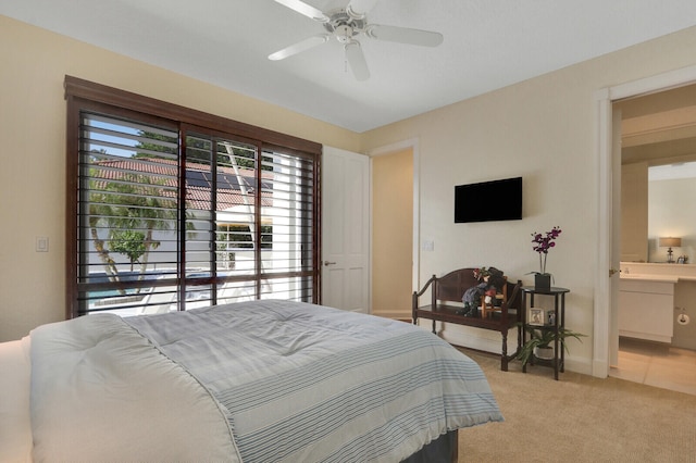 carpeted bedroom with ensuite bath and ceiling fan