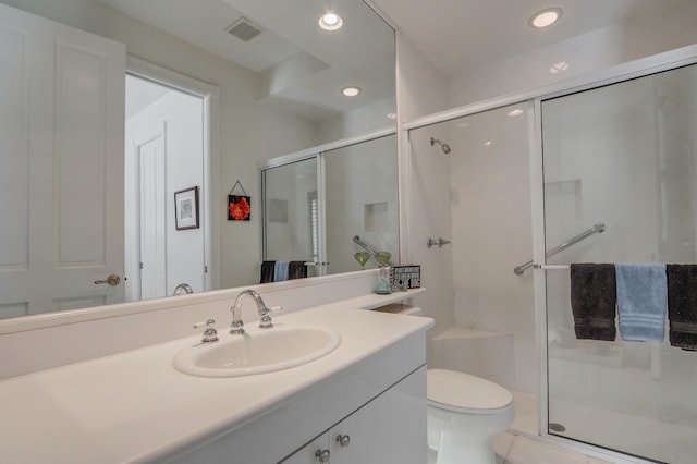 bathroom featuring toilet, vanity, and walk in shower