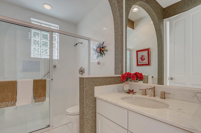 bathroom featuring tile patterned floors, vanity, toilet, and an enclosed shower