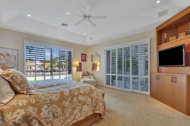 carpeted bedroom with access to outside, ceiling fan, and a tray ceiling