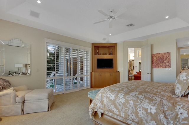 carpeted bedroom with a tray ceiling, access to exterior, and ceiling fan