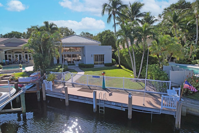 view of dock with a water view and a lawn