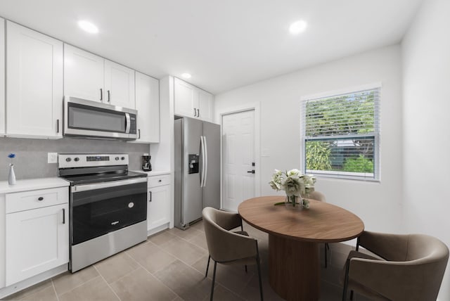 kitchen with white cabinets, stainless steel appliances, and tasteful backsplash