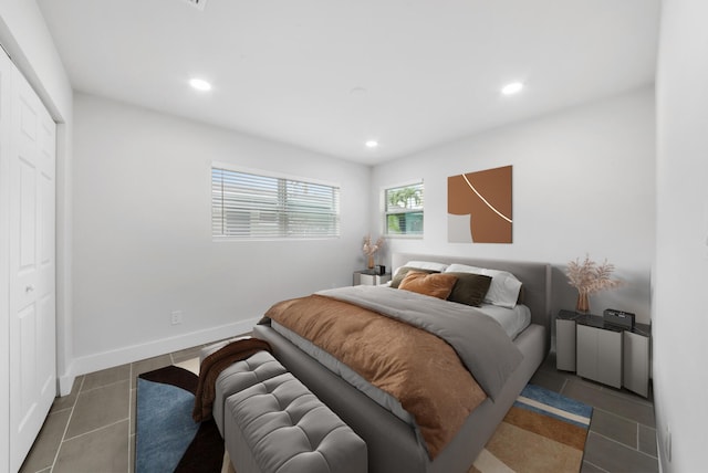 bedroom featuring dark tile patterned floors and a closet