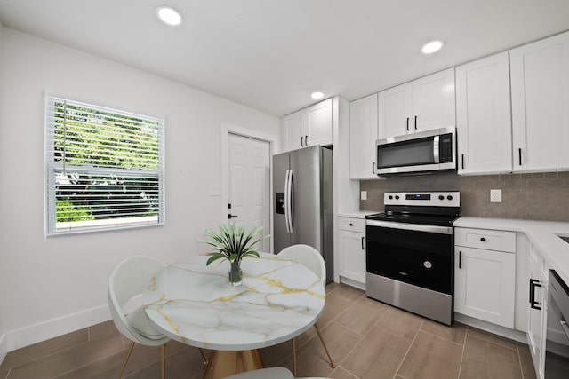 kitchen featuring decorative backsplash, white cabinetry, and stainless steel appliances