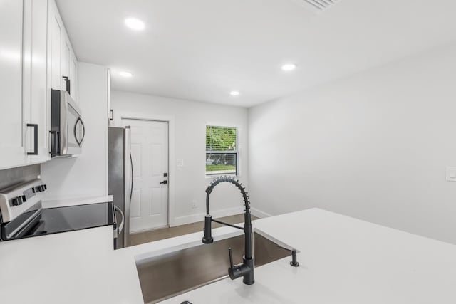 kitchen with sink, white cabinets, and appliances with stainless steel finishes