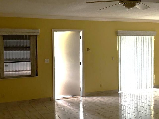 tiled spare room with a textured ceiling, ceiling fan, and crown molding