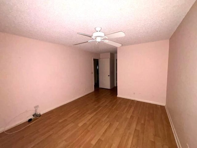 spare room with ceiling fan, wood-type flooring, and a textured ceiling