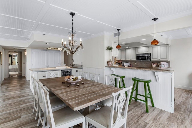 dining space featuring ornamental molding, sink, wine cooler, and light wood-type flooring