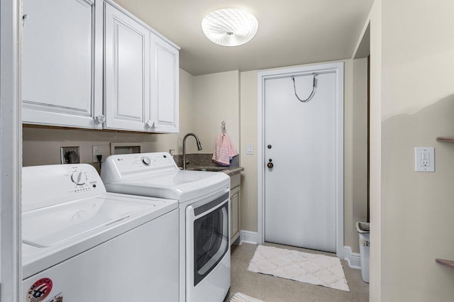 clothes washing area with cabinets, sink, and washing machine and clothes dryer