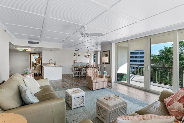 living room featuring hardwood / wood-style flooring, floor to ceiling windows, sink, and ceiling fan