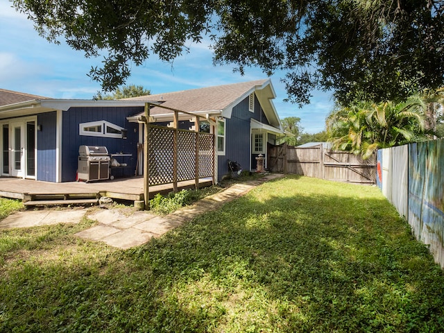 view of side of home with a yard and a wooden deck