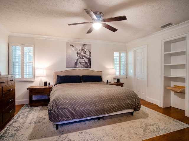 bedroom featuring dark hardwood / wood-style floors, multiple windows, and ceiling fan