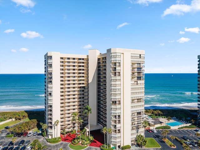 view of building exterior with a water view and a view of the beach