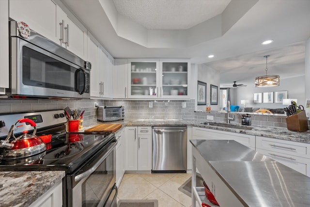 kitchen with light tile patterned floors, white cabinetry, and appliances with stainless steel finishes