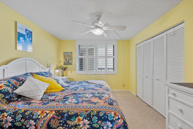 carpeted bedroom featuring ceiling fan, a textured ceiling, and a closet