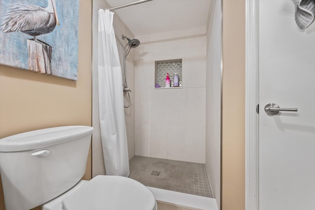 bathroom with a shower with curtain and toilet