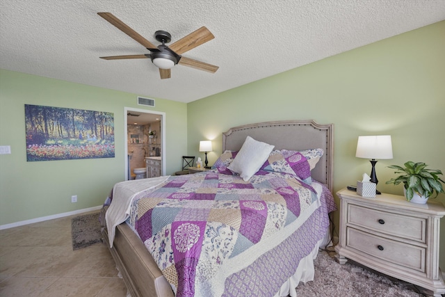 tiled bedroom with ensuite bathroom, ceiling fan, and a textured ceiling