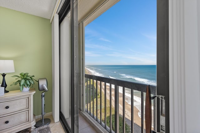 balcony featuring a view of the beach and a water view