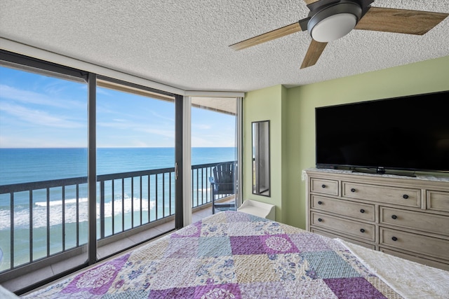 bedroom featuring floor to ceiling windows, ceiling fan, tile patterned flooring, a textured ceiling, and access to outside