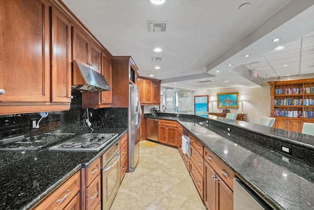 kitchen with sink, dark stone counters, decorative backsplash, light tile patterned flooring, and appliances with stainless steel finishes