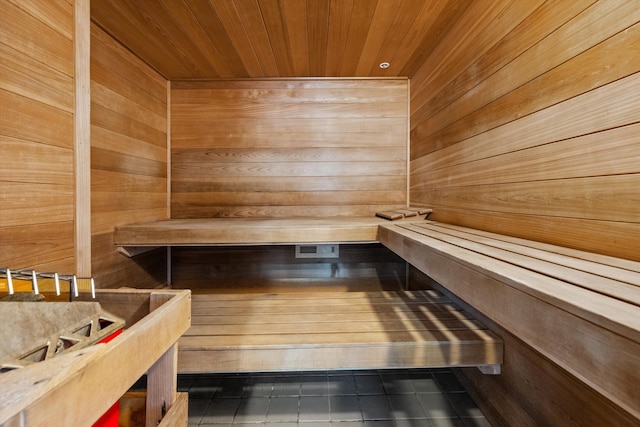 view of sauna featuring tile patterned flooring, wooden walls, and wooden ceiling