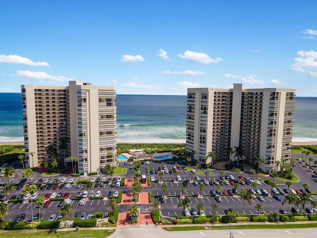 view of building exterior featuring a water view and a beach view