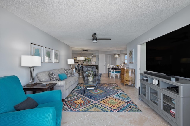 living room featuring light tile patterned floors, a textured ceiling, and ceiling fan