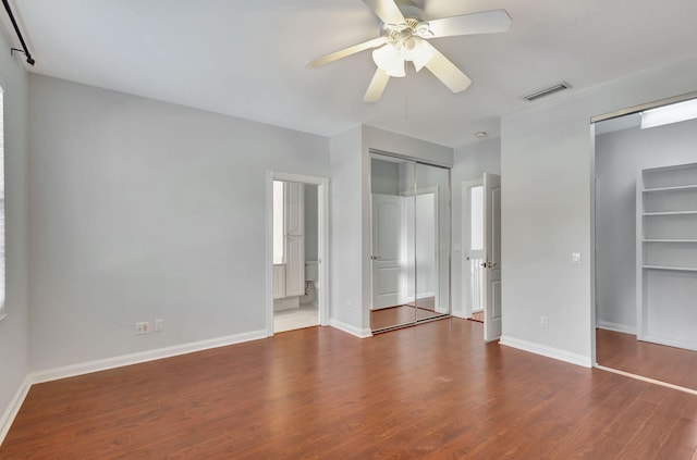 unfurnished bedroom featuring hardwood / wood-style flooring, ceiling fan, and ensuite bath