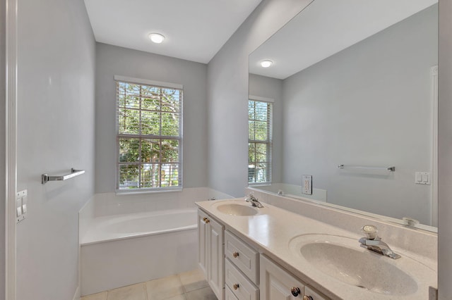 bathroom with a bathtub, tile patterned flooring, vanity, and a healthy amount of sunlight